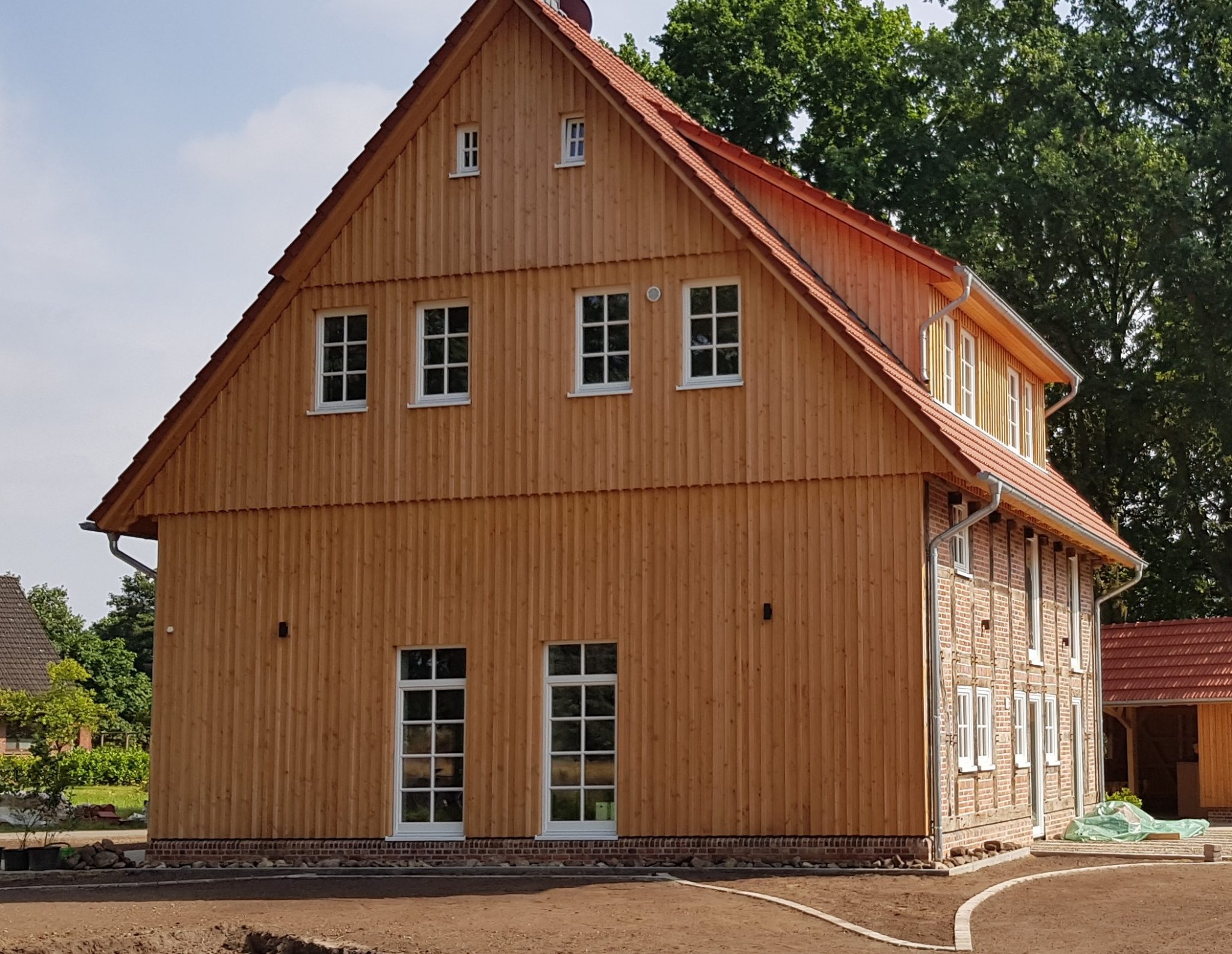 Sanierte Hofstelle mit neuer Holzfassade und Dacheindeckung, ausgeführt von der Zimmerei Frese
